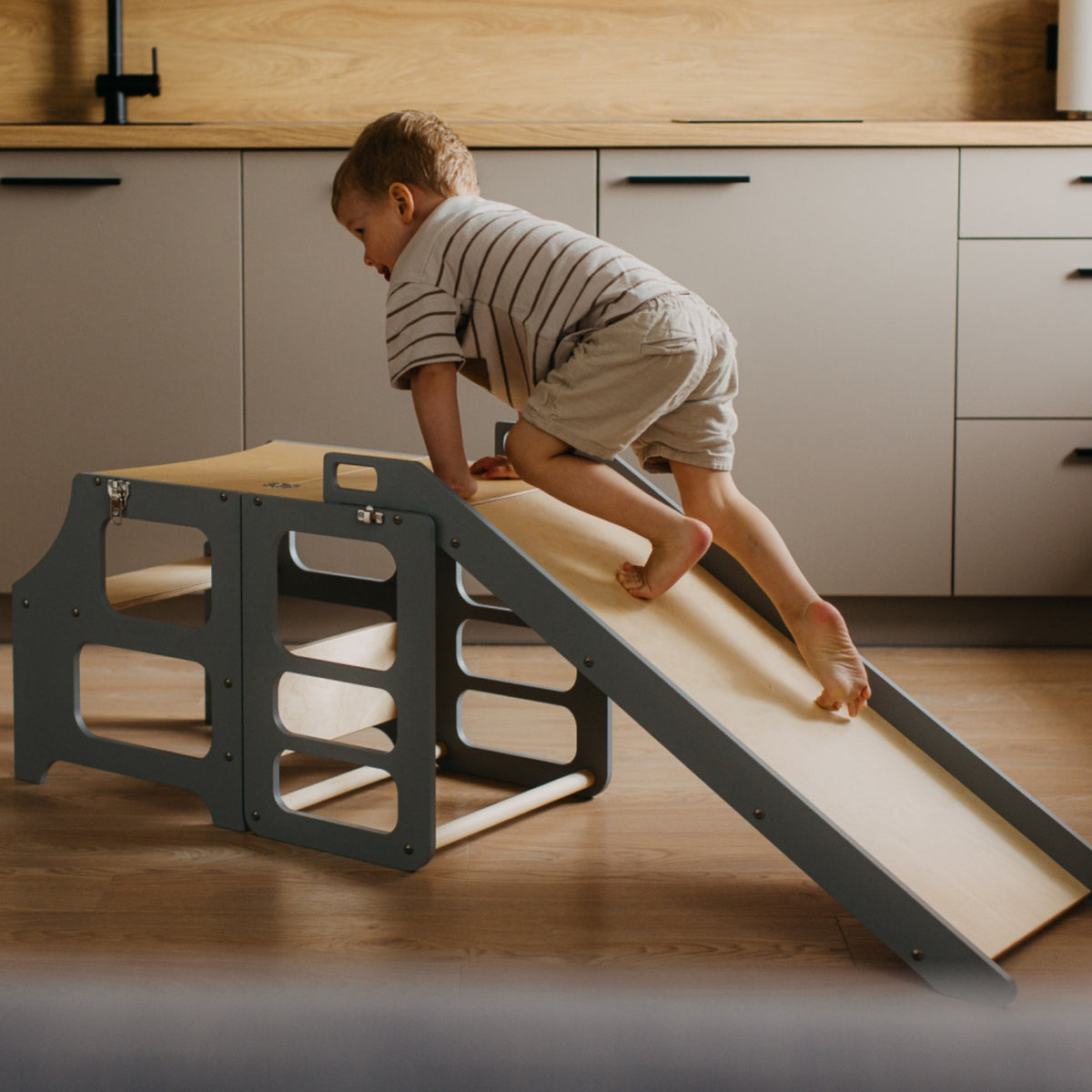 var:grau-lernturm-rutsche / Kind nutzt Lernturm-Rutsche in Grau – Indoor-Spielspaß & Motorikförderung