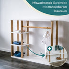 Der Montessori Kleiderschrank ohne montierten Stauraum steht vor einer weißen Wand. Rechts eine Nahaufnahme deas Stauraumes mit einem Pfeil und oben rechts der Text "Mitwachsende Garderobe mit montierbarem Stauraum"