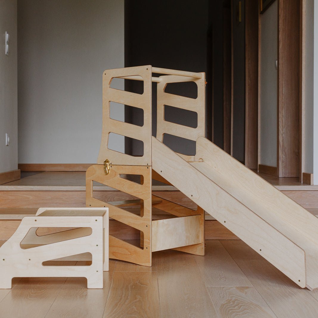 var:klarlack-lernturm-rutsche-hocker / Der Lernturm mit Tischfunktion im Streifen-Design in Klarlack mit Rutsche und Extra-Hocker im Fokus.