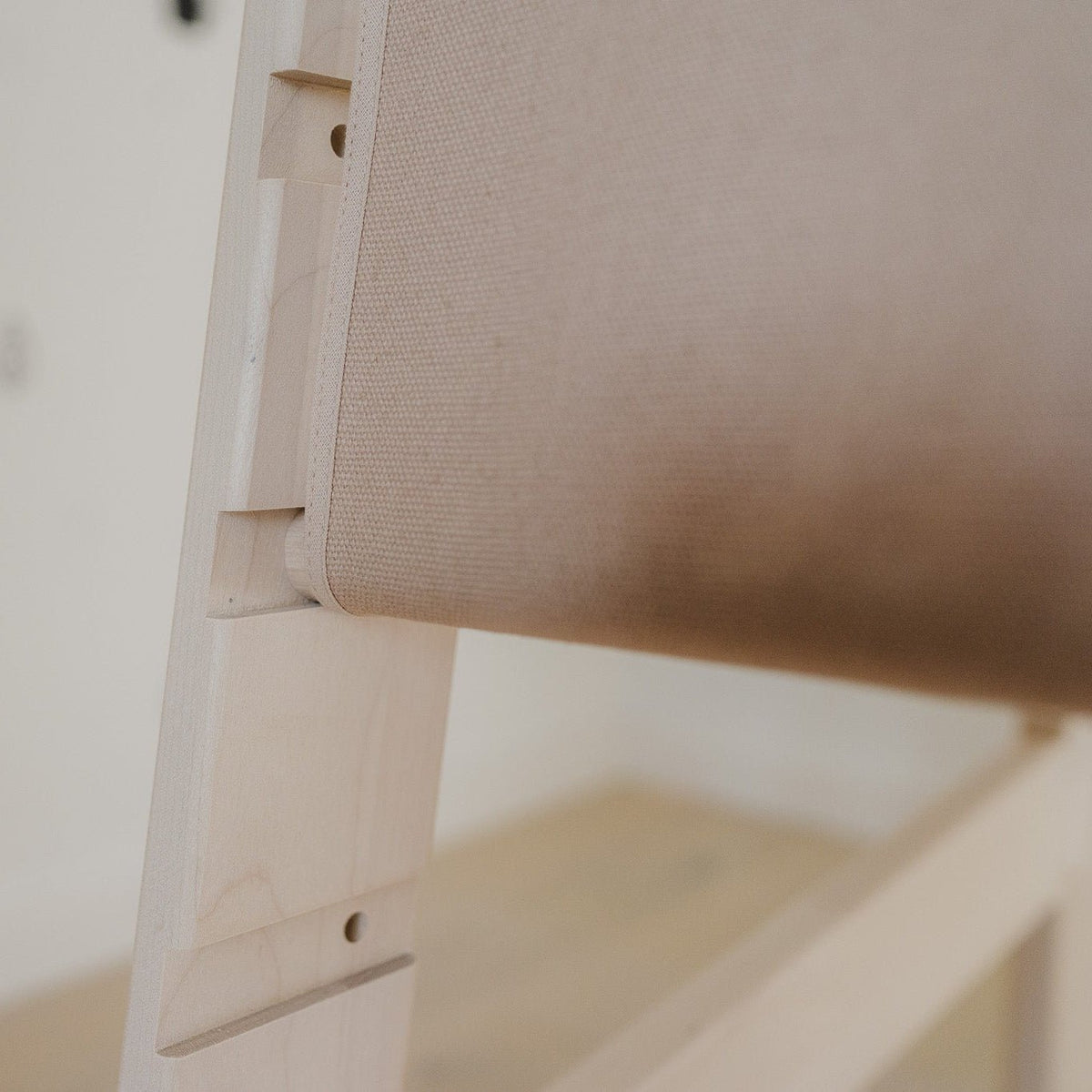 Nahaufnahme des Baumwollcovers, welches als Rausfallschutz für den Lernturm aus Massivholz dient sowie der Einkerbungen zur Höhenverstellbarkeit.