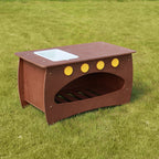 Die Matschüche steht mit leerem Behälter mittig im Garten.